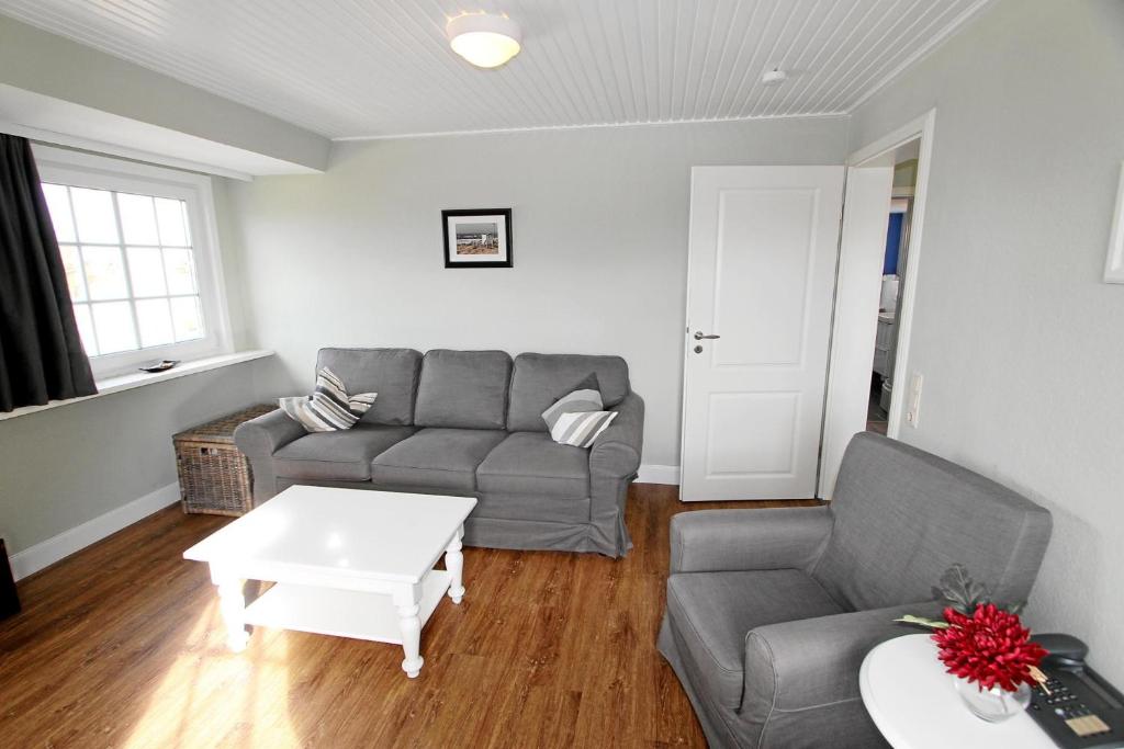 uma sala de estar com um sofá e uma mesa em Steffi - Ostmarkstr 20, App 2 em Wenningstedt