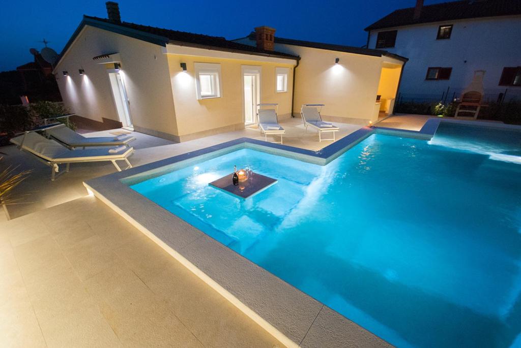 a swimming pool with a fire in the middle at Villa Manuela near Medulin with private pool only 500 meters from sea in Banjole