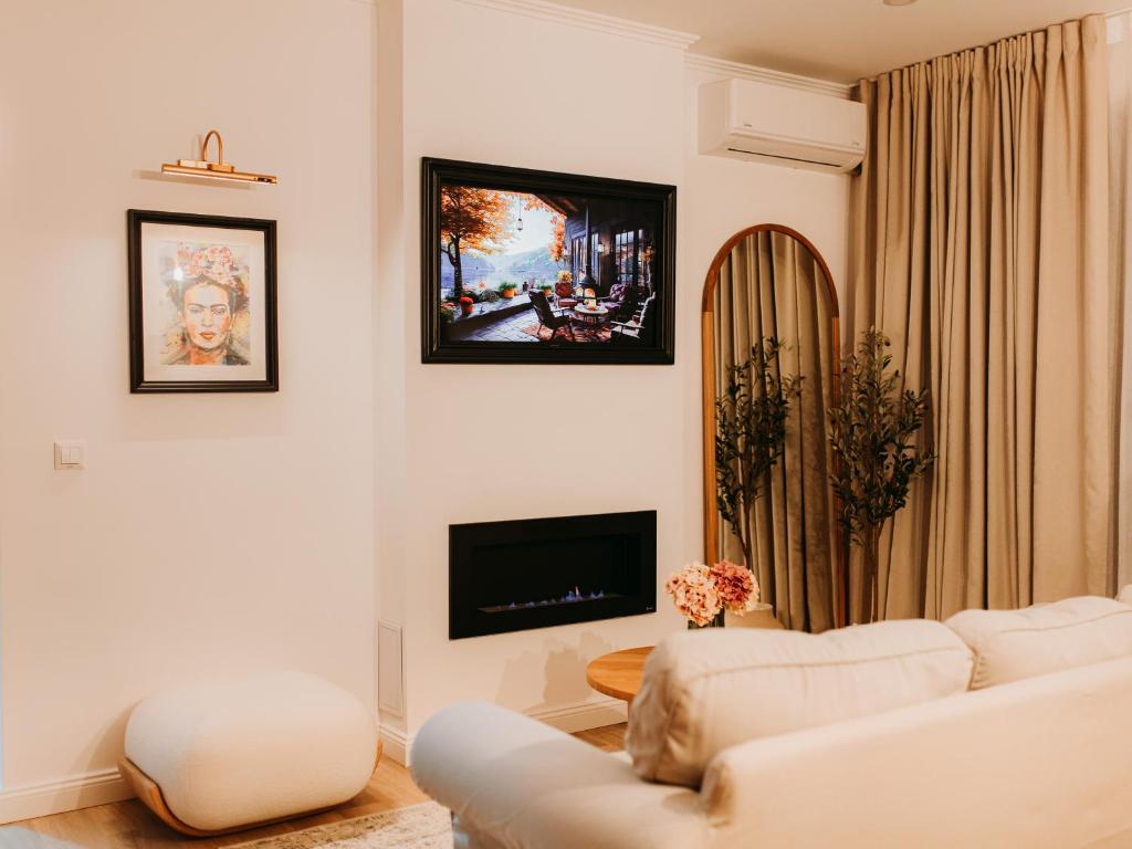 a living room with a white couch and a tv at GIA Apartment in Satu Mare