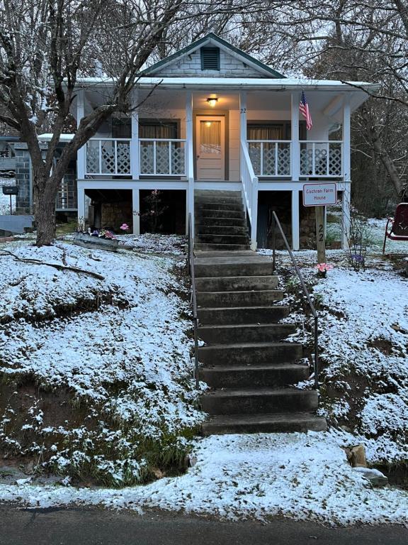 a white house with snow on the ground at Cochran Farm House in Bryson City
