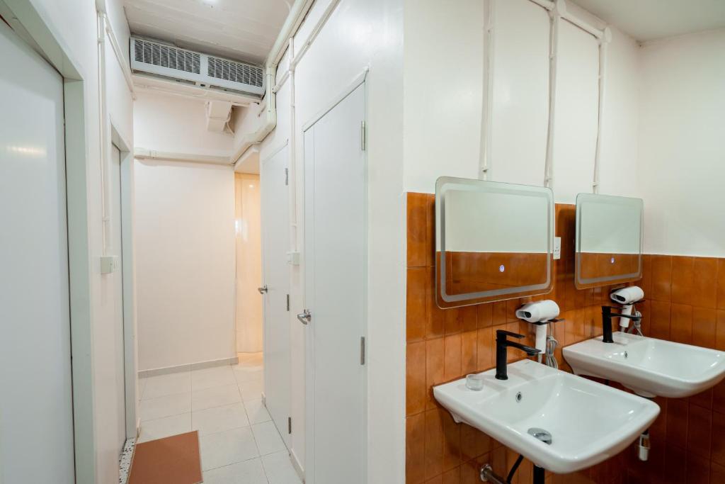 a bathroom with two sinks and two mirrors at Yimwhan House 02, Ayutthaya old town in Phra Nakhon Si Ayutthaya
