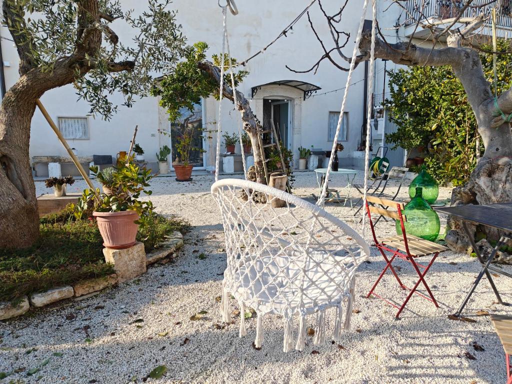 um baloiço num quintal com cadeiras e árvores em Masseria Casino Ciomme em Gioia del Colle