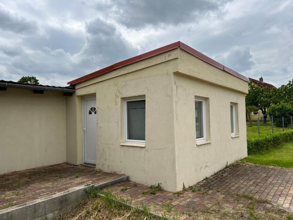 a small white building with a window and a door at T8 BUDGET 2 Bedroom+Living room Apartment @ agglomeration Taplanszentkereszt in Szombathely