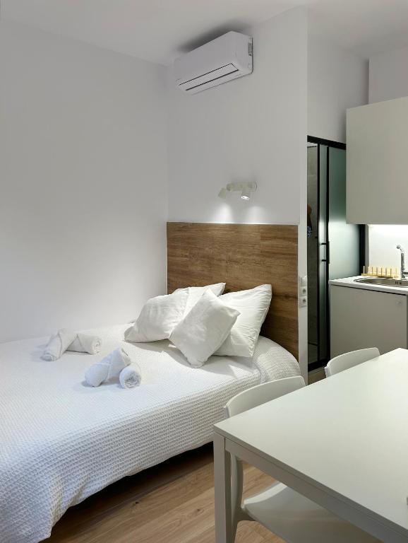 1 dormitorio con cama blanca y mesa en SD Habitación céntrica con baño y minicocina, en Terrassa