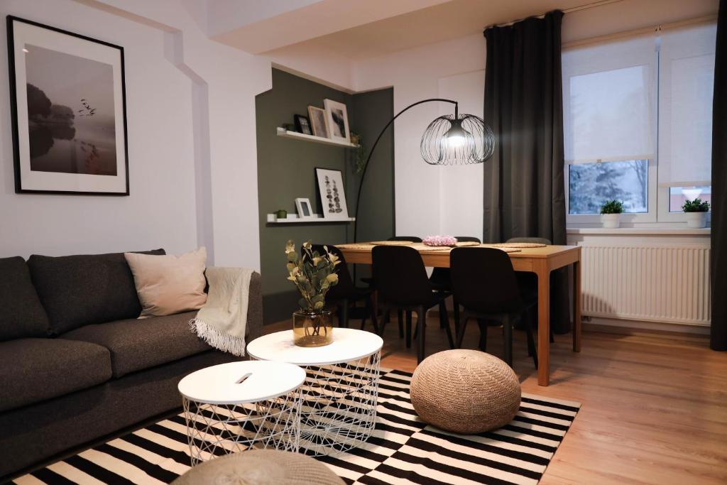 een woonkamer met een bank en een tafel bij Forest View Apartment in Jáchymov