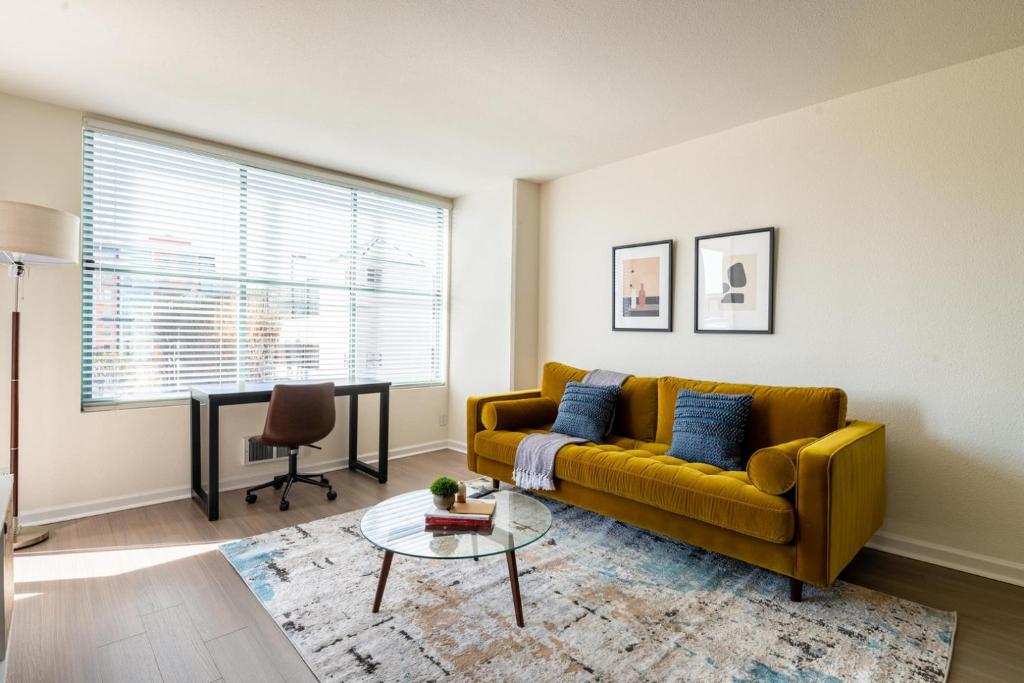 ein Wohnzimmer mit einem gelben Sofa und einem Tisch in der Unterkunft South Beach 1br across the street from SF bay SFO-1661 in San Francisco