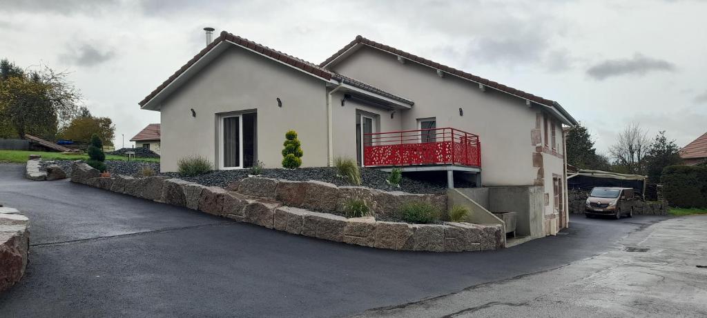 uma casa branca com uma varanda vermelha numa entrada em Gite de la Creuse (Vosges) em Fays