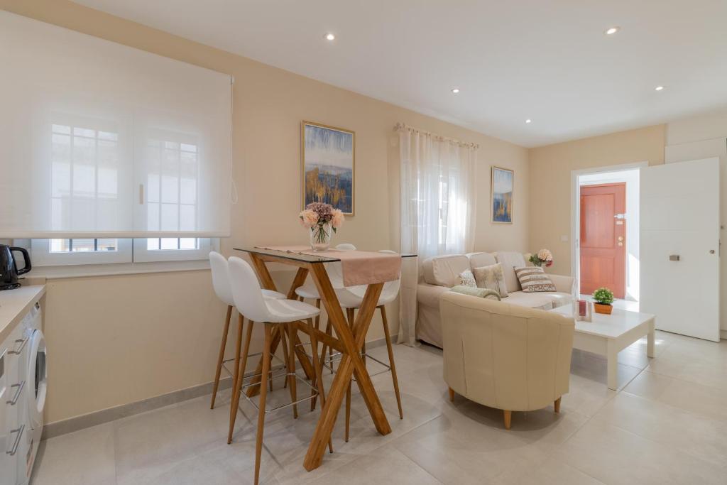 a kitchen and living room with a table and a couch at Luxury El Patio de la Judería in Córdoba