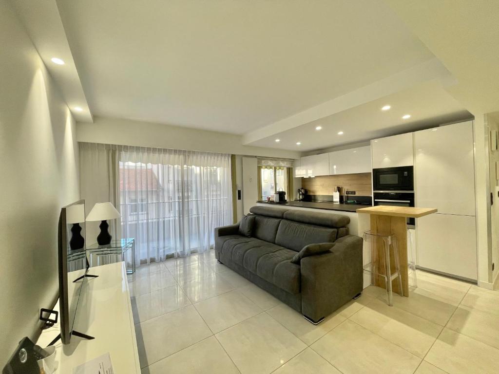 un salon avec un canapé et une cuisine dans l'établissement Branly 4, by Welcome to Cannes, à Cannes