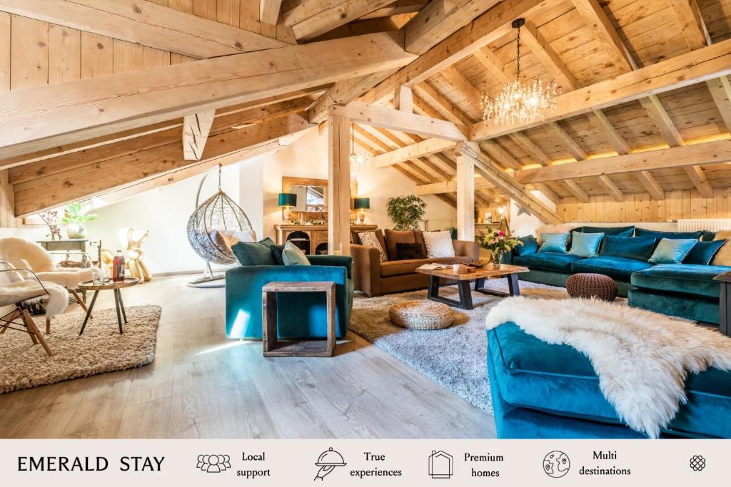 a living room with blue furniture and wooden ceilings at Chalet Chu Lo Dou Le Praz Courchevel - by EMERALD STAY in Courchevel