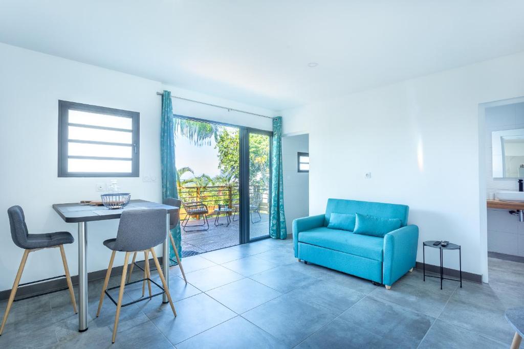 a living room with a blue couch and a table at Leu Jardin in Saint-Leu