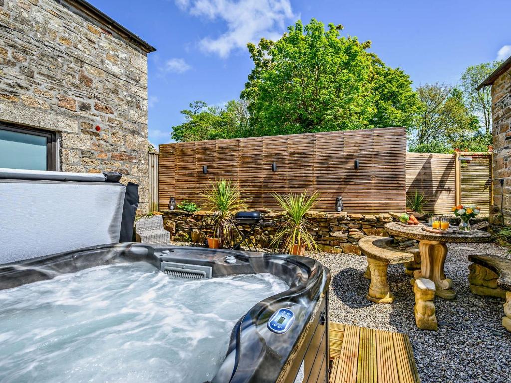 a hot tub in a backyard with a table at 2 Bed in Lanhydrock 90216 in Bodmin