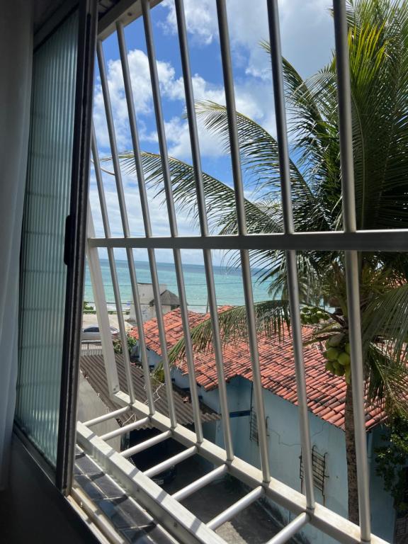 uma vista a partir de uma janela da praia em Apartamento na orla de Olinda em Olinda
