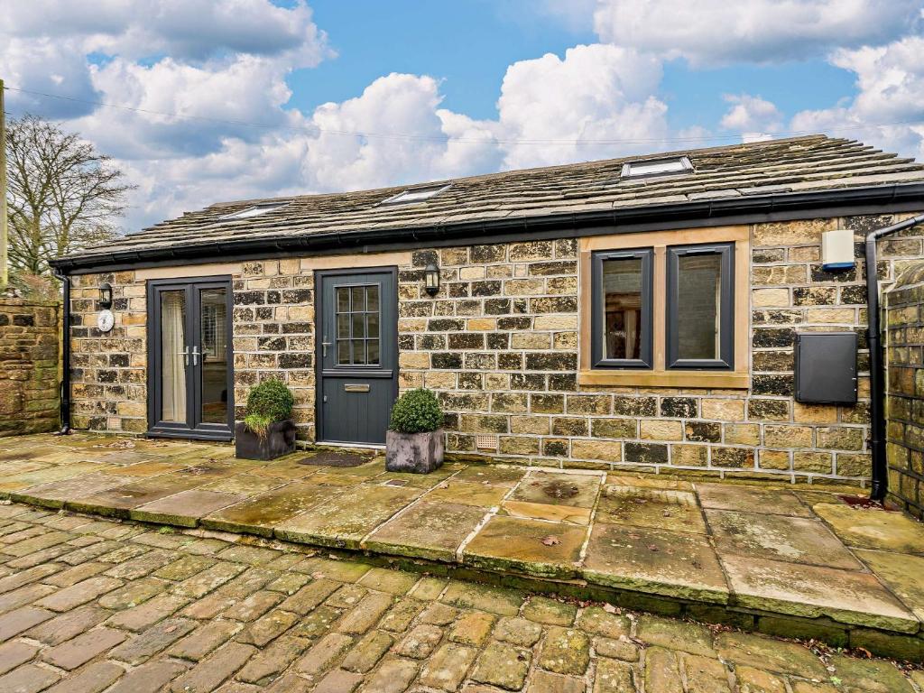 una casa de ladrillo con dos macetas delante de ella en 1 Bed in Sowerby Bridge 90213 en Sowerby Bridge