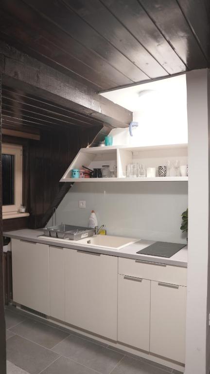 a kitchen with white cabinets and a counter top at Vučko apartmani Konaci in Kopaonik