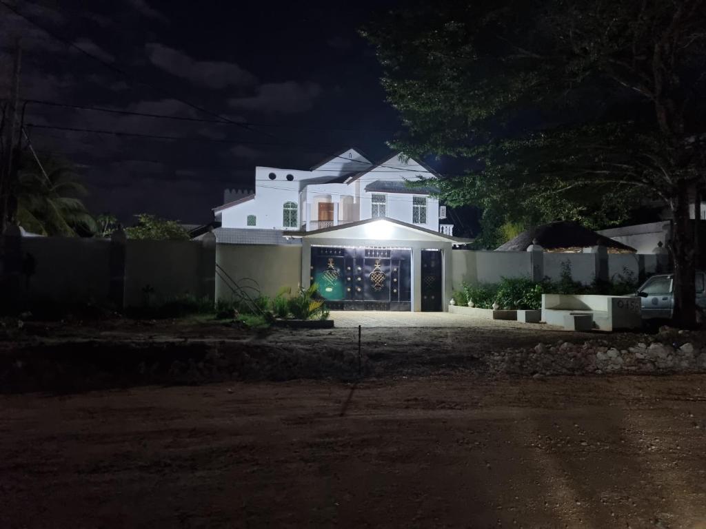 a house with a light on the front at night at 64 ZENJ HOUSE Luxury Airport B&B in Mbweni