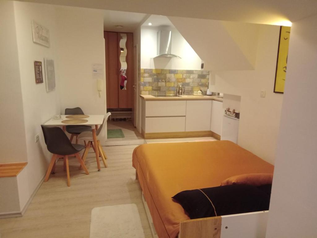 ein Schlafzimmer mit einem Bett und einem Tisch sowie eine Küche in der Unterkunft HappyGuest Apartment in Koper