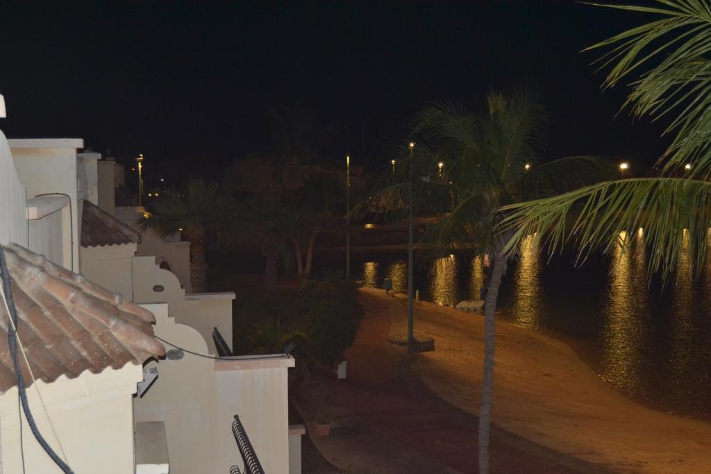 - une vue sur un bâtiment et des palmiers la nuit dans l'établissement منتزة درة العروس, à Taif