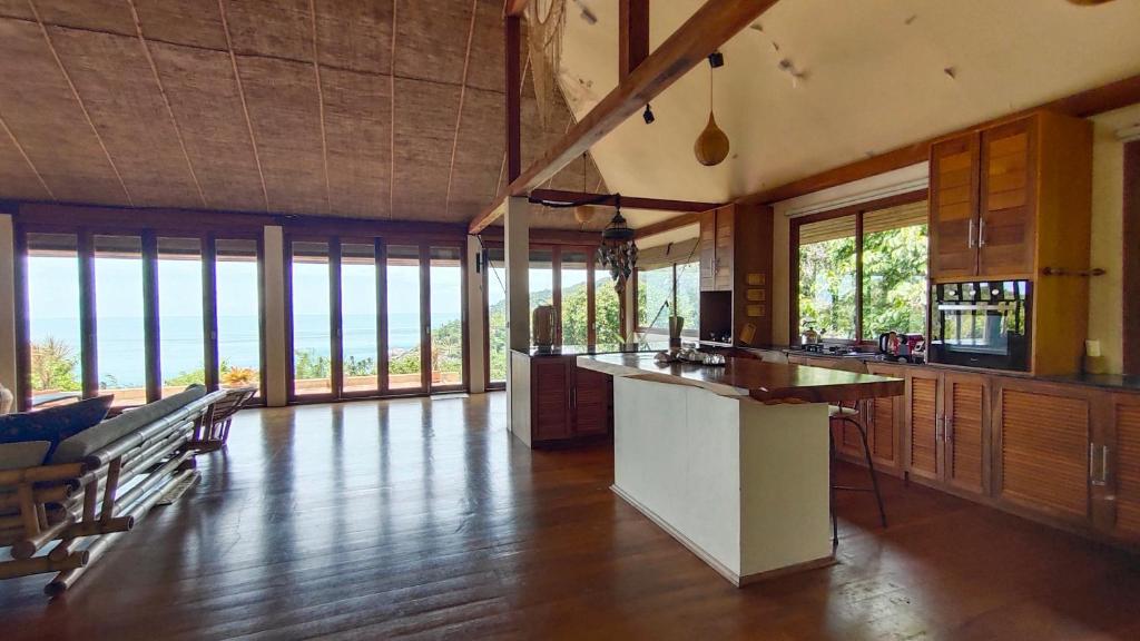 a large kitchen with a counter and some windows at Why Nam Beach in Haad Yuan