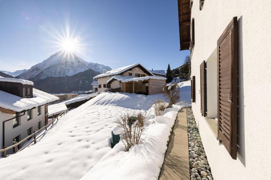 um quintal coberto de neve com uma montanha ao fundo em Chasa Val Parterre em Scuol