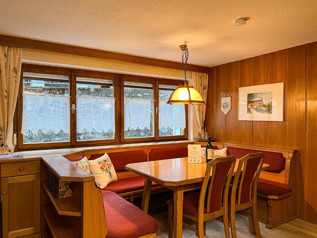 uma sala de jantar com uma mesa e uma mesa e cadeiras em Spitzen Blicke – Apartments em Silbertal