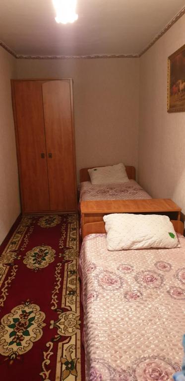 Turksibにある2- ух комнатная квартираのベッド2台とキャビネット付きの小さな部屋です。