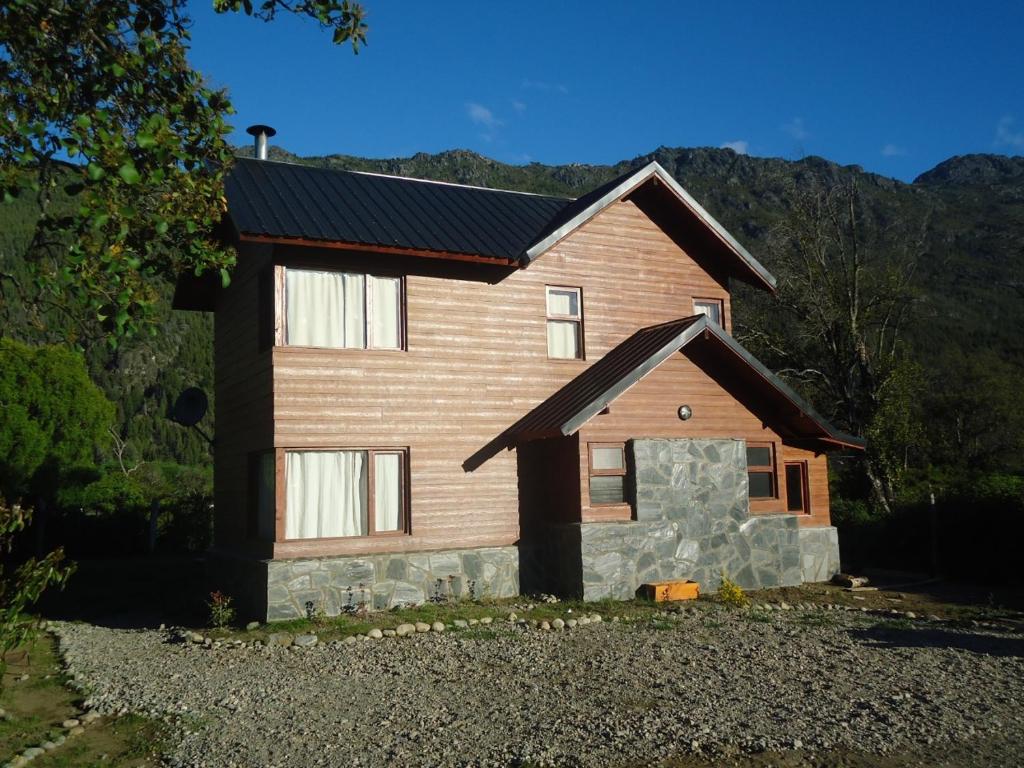 una casa marrón con piedra en Cabañas Peñi Huen en Lago Puelo