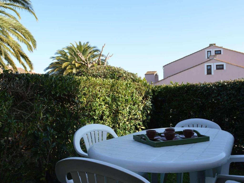- une table blanche avec des chaises et un plateau de nourriture dans l'établissement Appartement T2 avec Piscine, Proche Plage, Terrasse et Parking Privé à Saint-Cyprien - FR-1-225D-14, à Saint Cyprien Plage