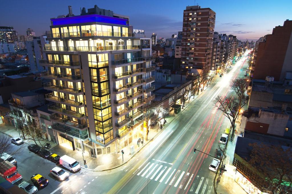 a city street with a tall building at night at Byblos Palermo Soho in Buenos Aires
