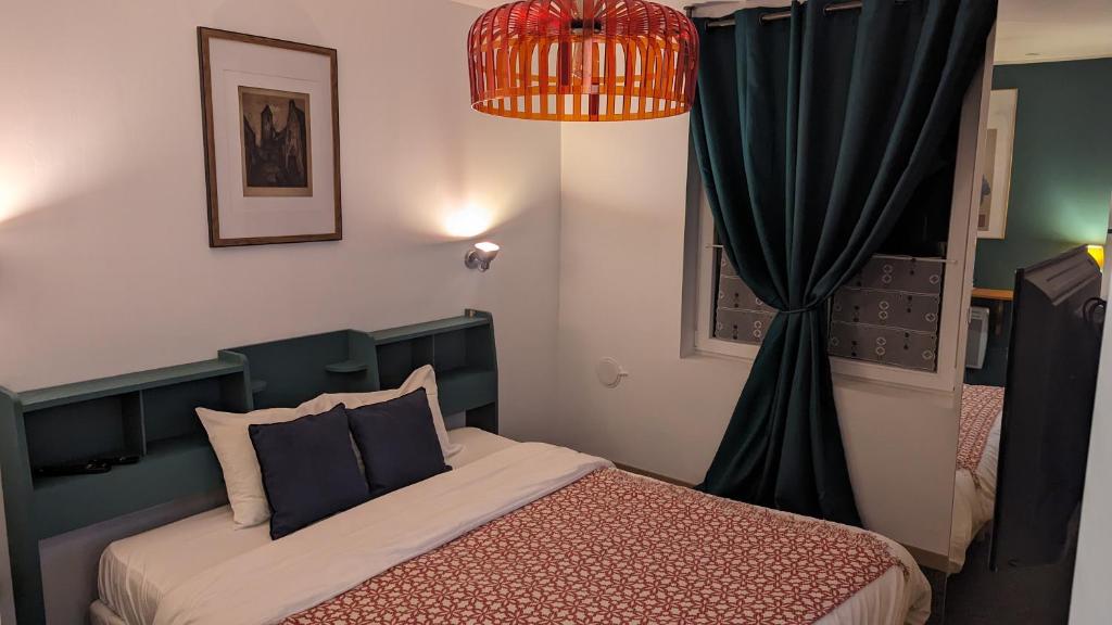 a bedroom with a bed and a black curtain at Aux Écuries Des Pres in Nogent-sur-Seine