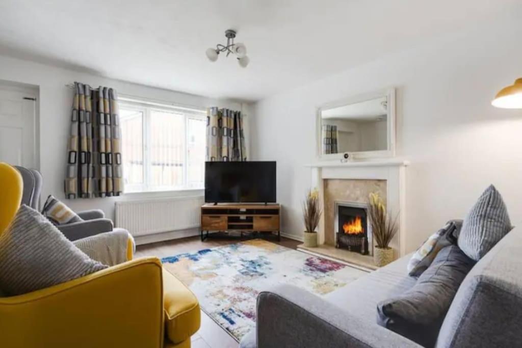 a living room with two couches and a fireplace at Newly renovated house near Trafford Centre in Manchester
