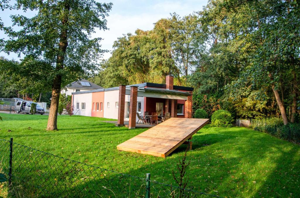 uma casa com uma rampa de madeira num quintal em Ferienhaus Erlengrund em Staphel