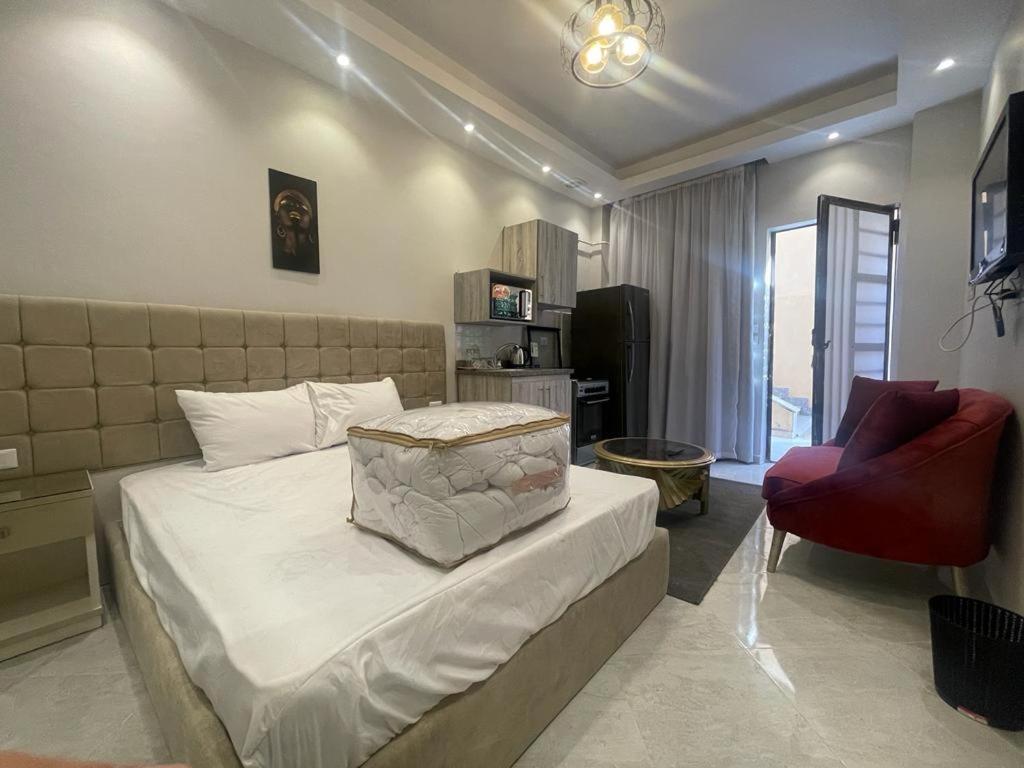 a bedroom with a bed and a red chair at Luxury Host-180 Sheikh-Zayed in Sheikh Zayed