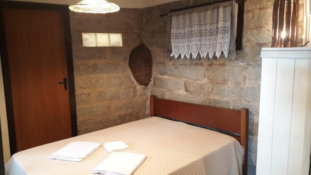 een slaapkamer met een bed met twee handdoeken erop bij Pororoca_rosa in Imbituba