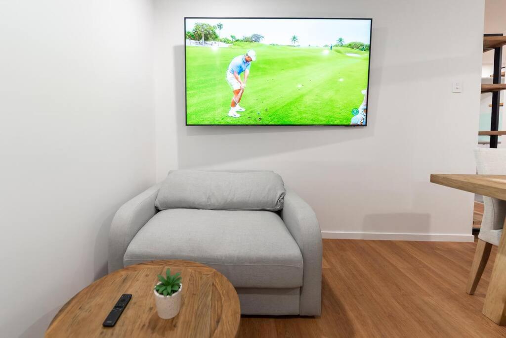 布里斯班Relaxation 2BR/1.5BA House w Parking near Beach的客厅里有一张沙发，墙上有一台电视