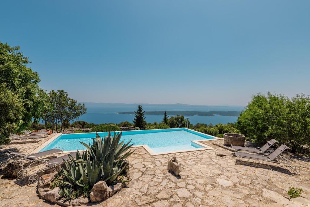 una piscina con vista sull'oceano di Outstanding Hvar Villa - 4 Bedrooms - Villa Dvori Pogled - Tennis Court - Incredible Sea Views a Jelsa (Gelsa)