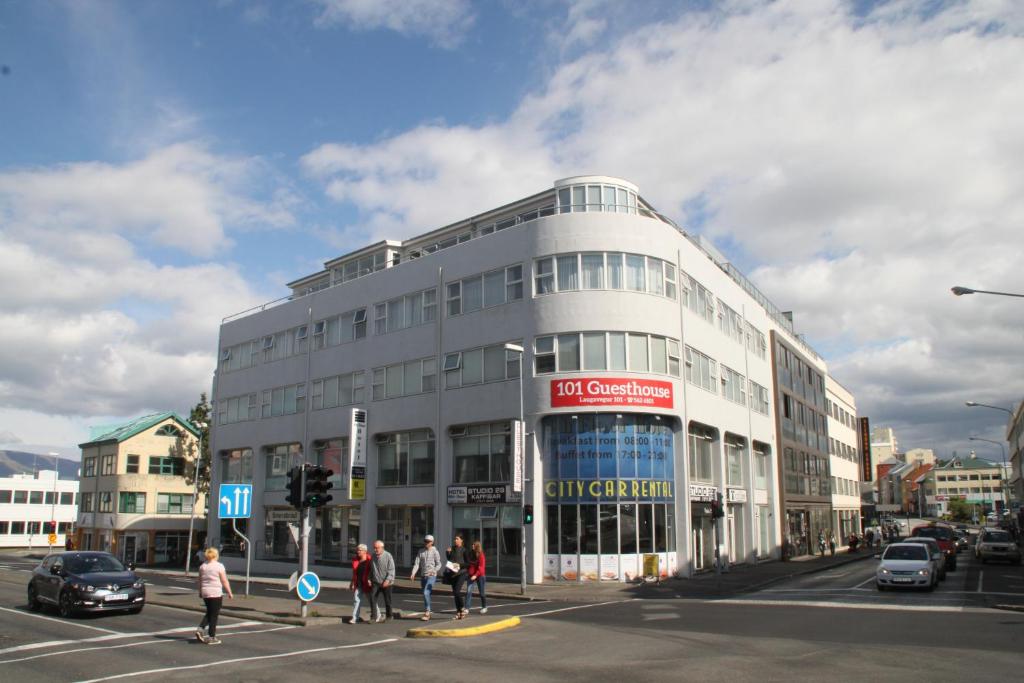 persone che attraversano una strada di fronte a un edificio di 101 Guesthouse Hotel a Reykjavik