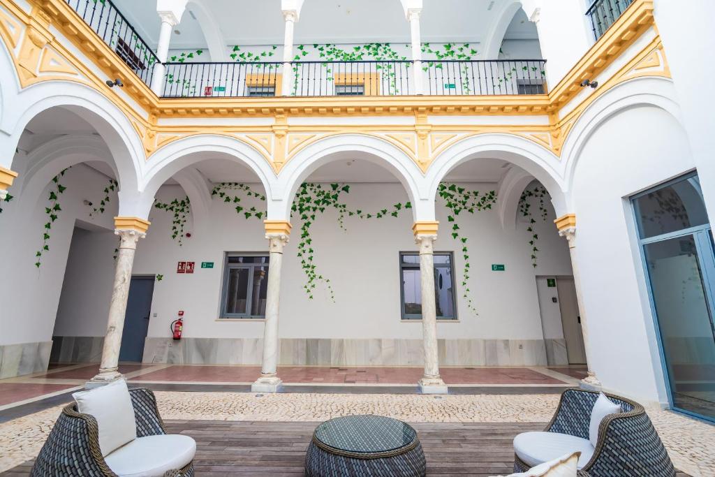 ein Zimmer mit Stühlen und einem Tisch in einem Gebäude in der Unterkunft IVY HOUSE in Sevilla
