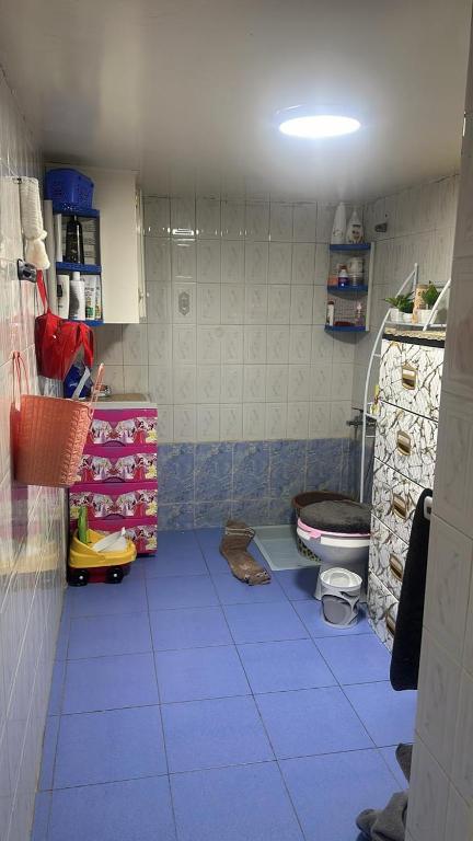 a bathroom with a blue tiled floor with a toilet at Dikra apparemment in Fez