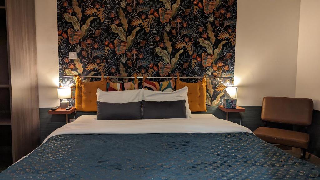 een slaapkamer met een groot bed met bloemenbehang bij Aux Écuries Des Pres in Nogent-sur-Seine