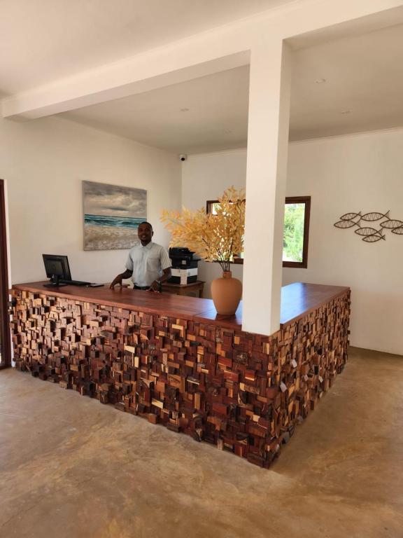 a man sitting at a counter in a room at Cabana Beach Lodge in Cabo Conguiane