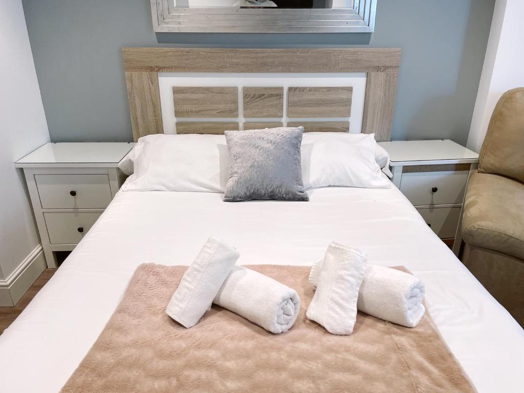 a large white bed with two pillows on it at Delightful City Centre Studio Clarendon Apartment - Grand Central House in Gibraltar