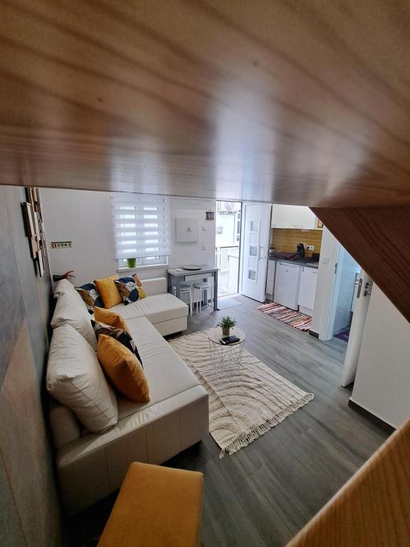 een woonkamer met een witte bank en een keuken bij Camarote Beach in Nazaré