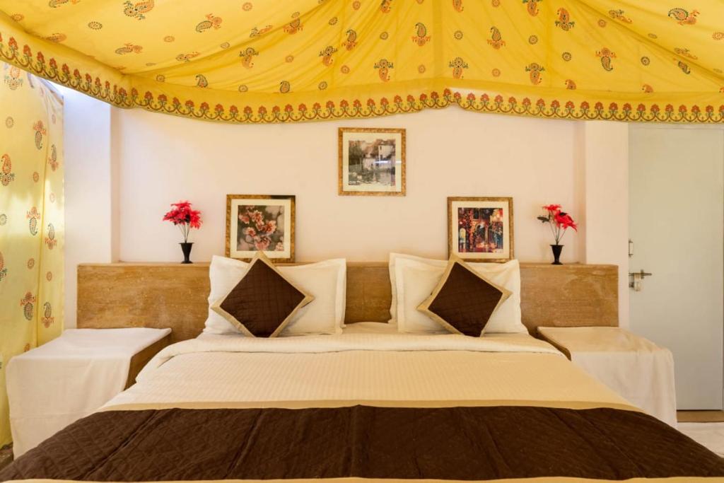 a bedroom with a large bed with a yellow ceiling at Sam Desert Luxury Resort in Sām