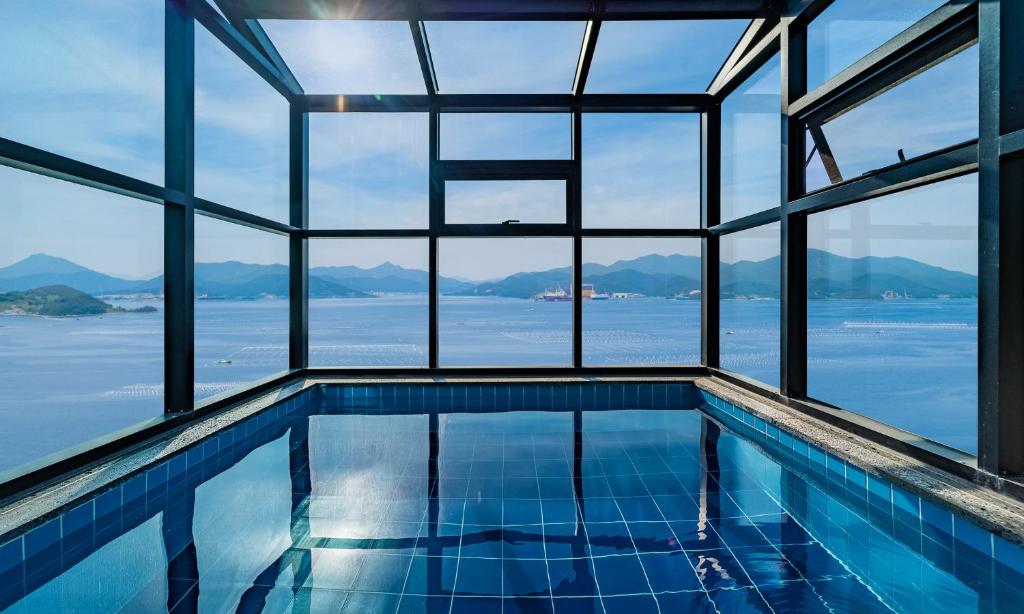 una piscina con vistas al agua y a las montañas en Stay 공간, en Geoje
