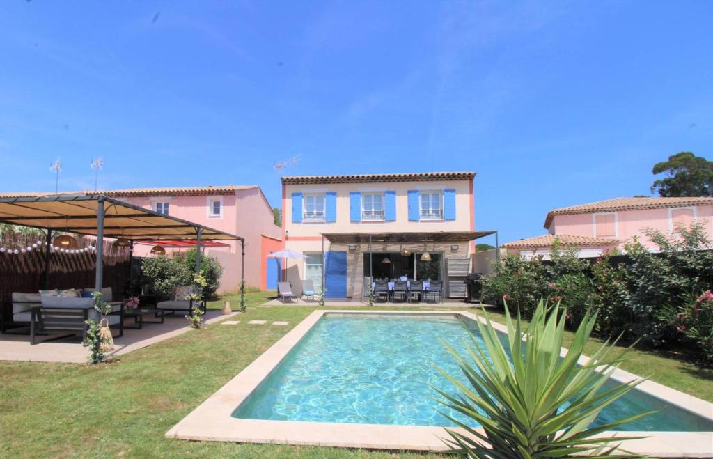 une maison avec une piscine dans une cour dans l'établissement Gridelaide 24 - A Grimaud dans le Golfe de St Tropez - Villa avec piscine privative à proximité de la plage, à Grimaud