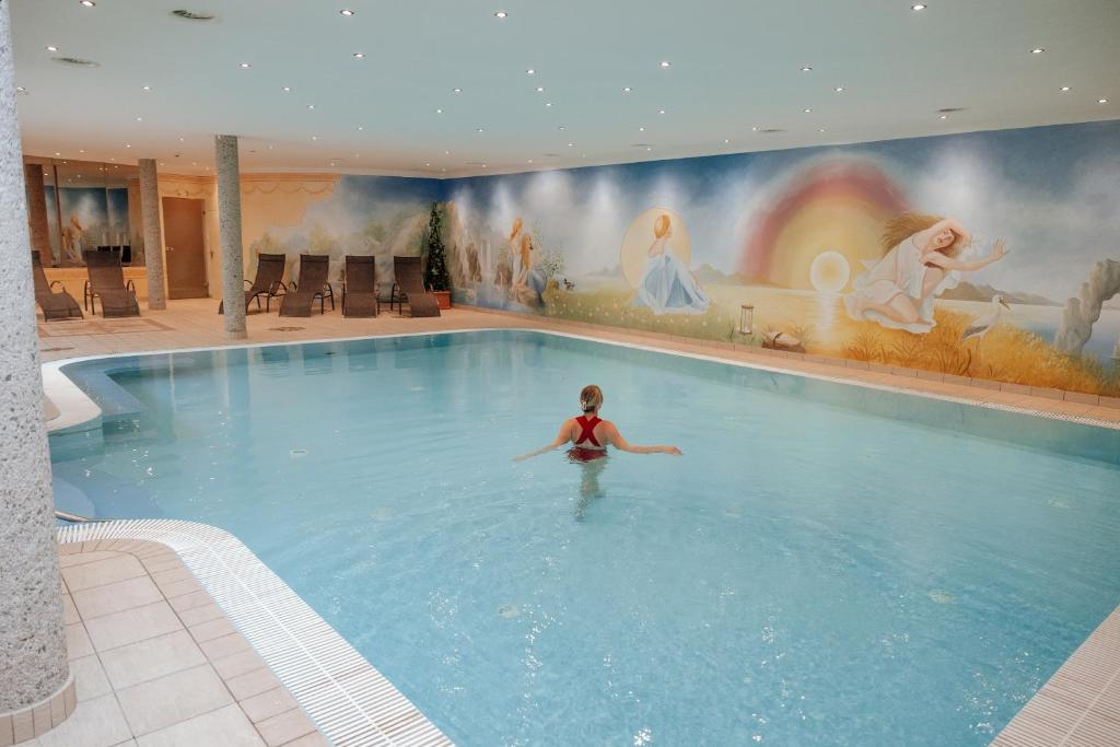 a child swimming in a large swimming pool at Hotel Glockenstuhl in Westendorf