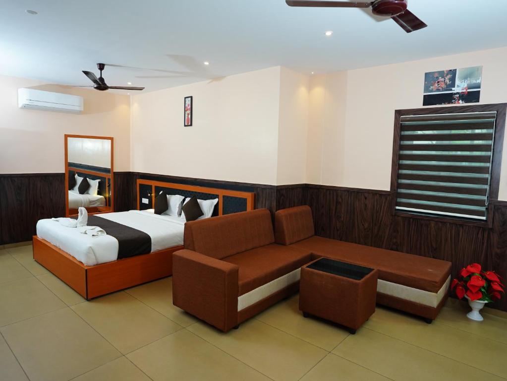 1 dormitorio con cama y sofá en ABUDHABI RESIDENCY, en Palakkad
