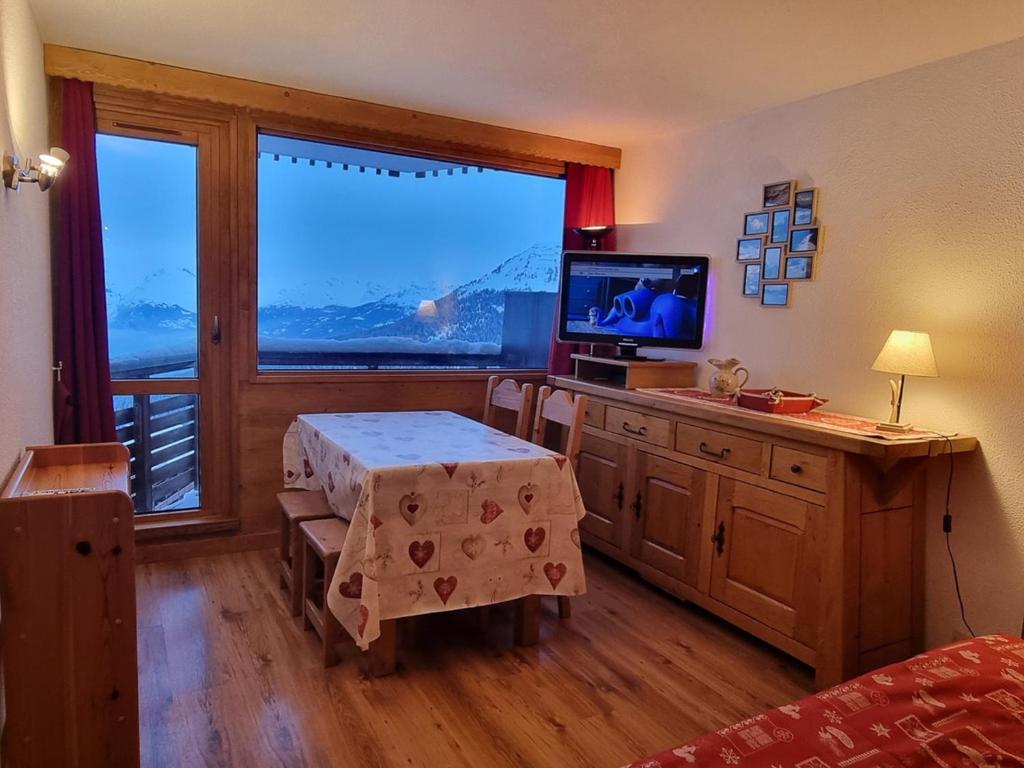 Cette chambre dispose d'une table, d'une télévision et d'une fenêtre. dans l'établissement Studio Chaleureux · Accès Pistes · Mont Blanc - FR-1-181-2569, à Aime La Plagne