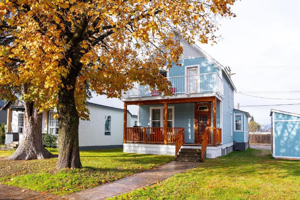 a blue house with a porch and a tree at Downtown Heritage Home W/ Hot Tub 509 Mackenzie in Revelstoke